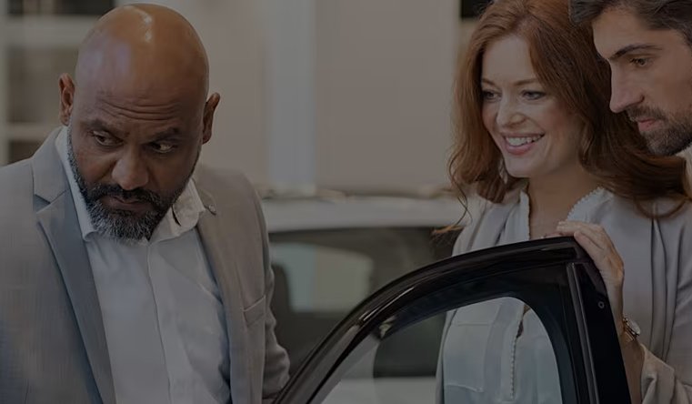 three people looking into a car interior