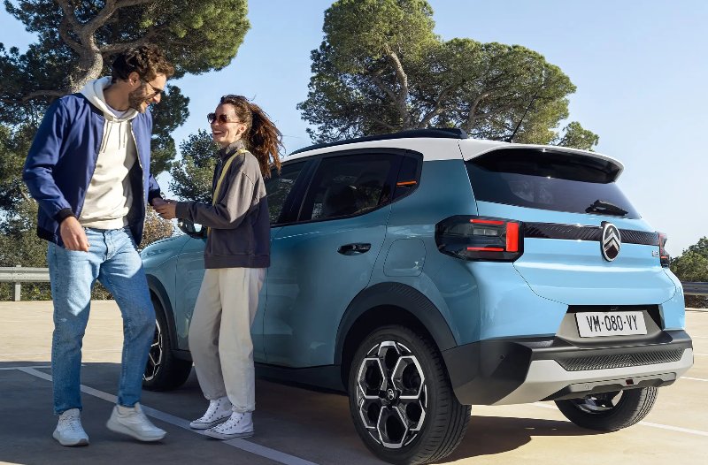 two people standing around the car