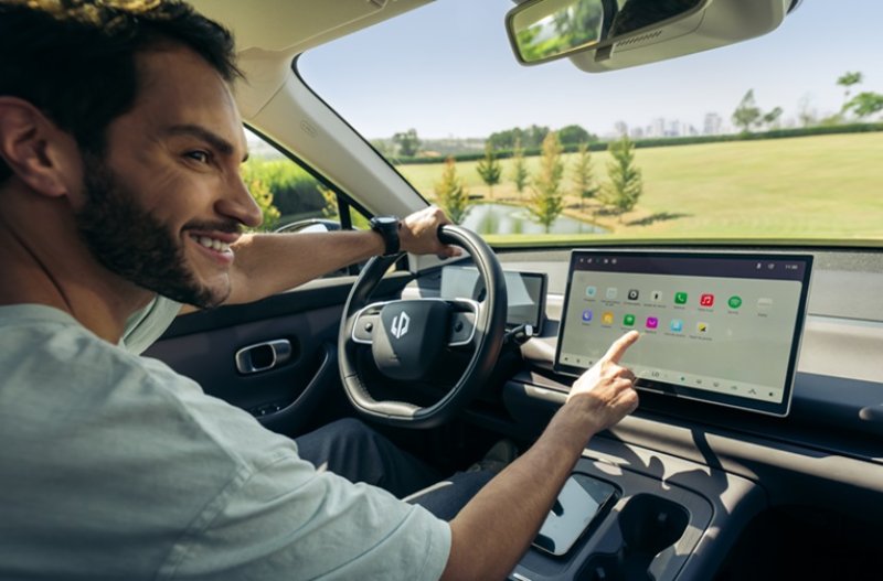 man in the driving seat touching the central console