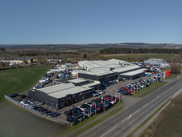 Aerial view of a large car dealership with rows of parked vehicles.
