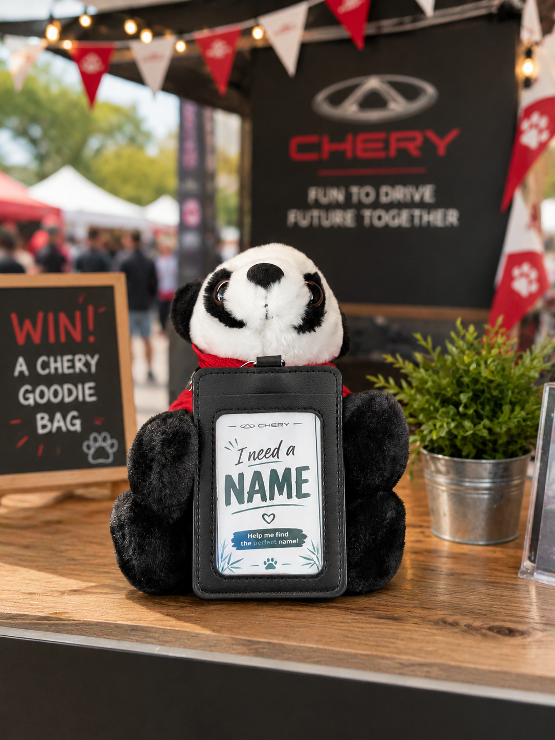 Stuffed panda with a sign that reads 'I need a name' at a Chery promotional booth.
