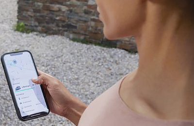Person holding a smartphone displaying a map app.