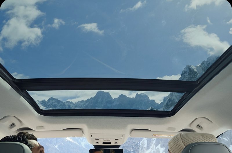 image of a car sunroof with two people looking up