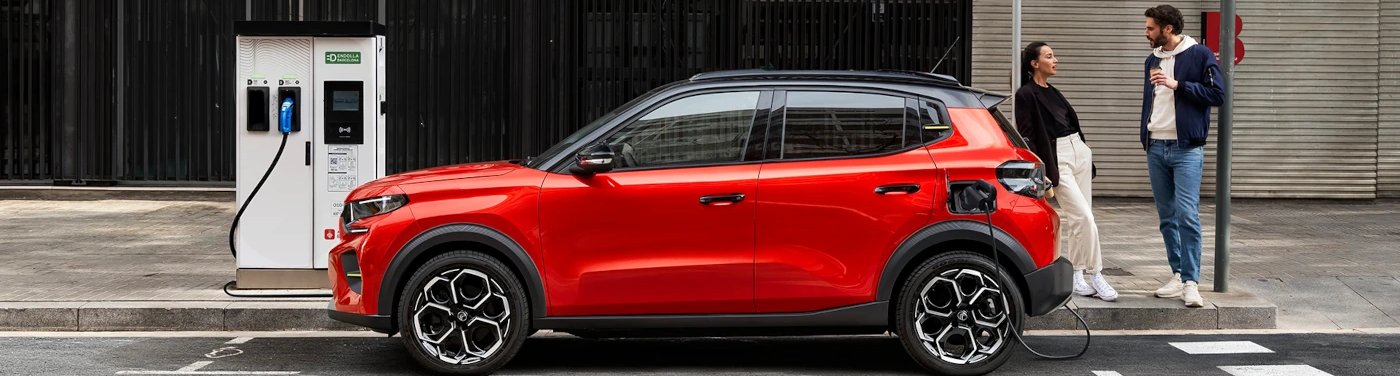 two people waiting by the car on charge
