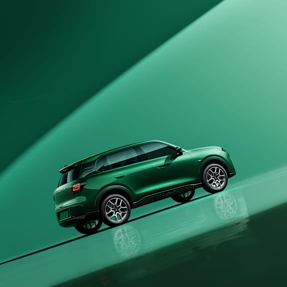 Green SUV car displayed on a glossy surface, viewed from the side.