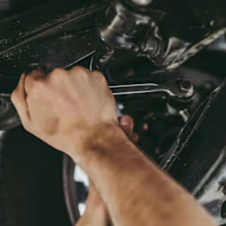 TWO HANDS UNDERNEATH THE CAR ENGINE