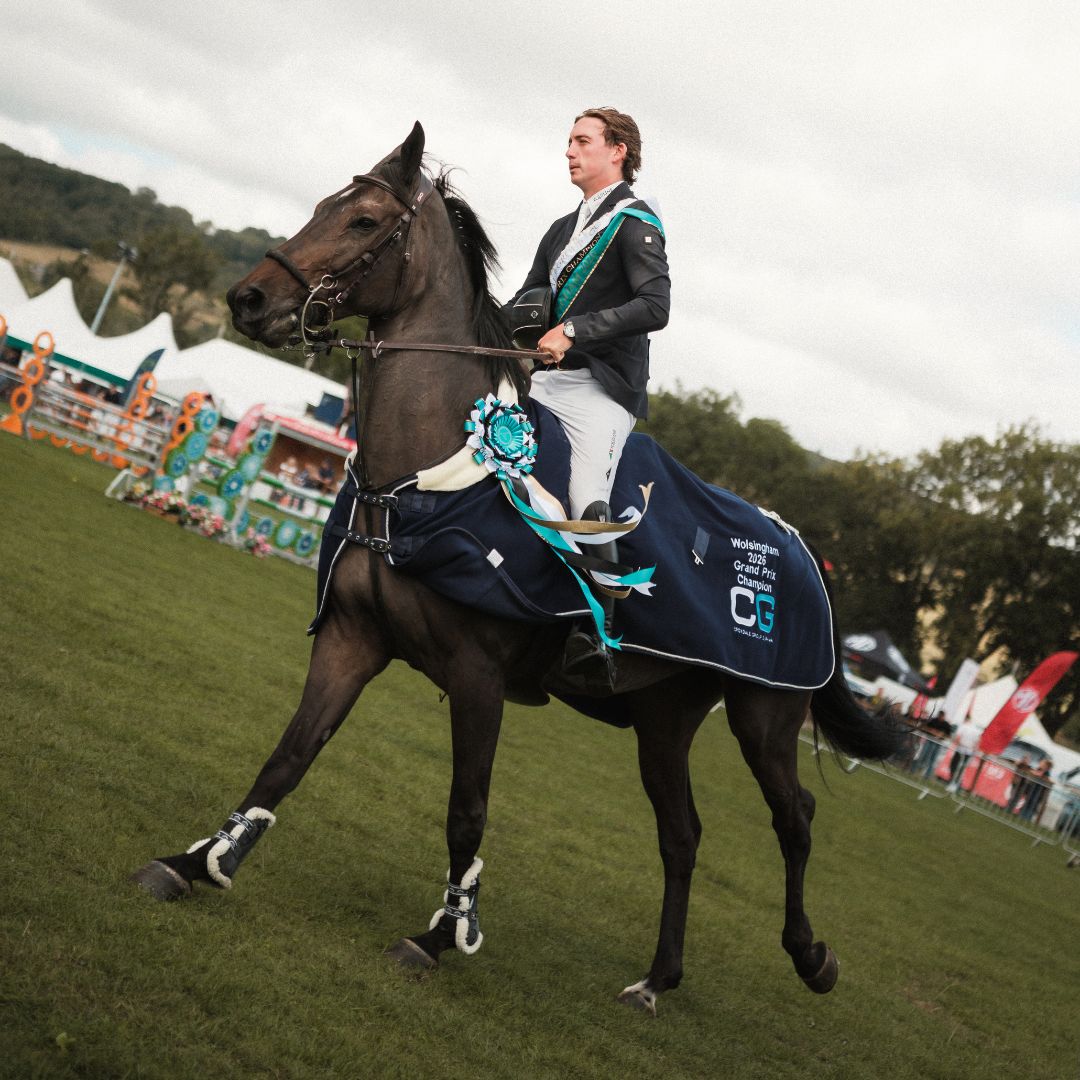 Jack Whitaker with blue ribbons riding Nimaran at a competition event.